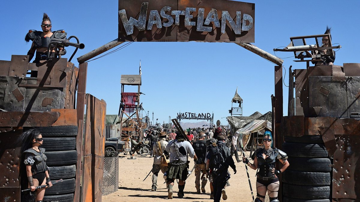 Ворота постапокалиптического фестиваля Wasteland в пустыне и участники в самодельной броне
